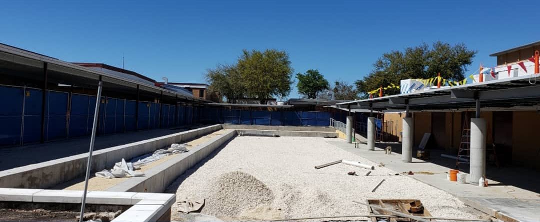 Bare gravel courtyard between two buildings before work began