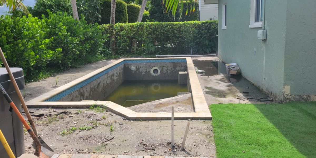 Before: empty pool shell surrounded by dirt and construction debris