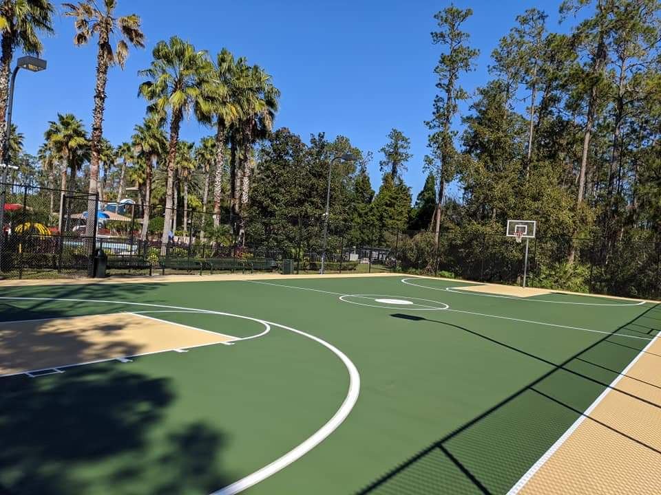 Half-court basketball court in green and tan acrylic coating with white lines