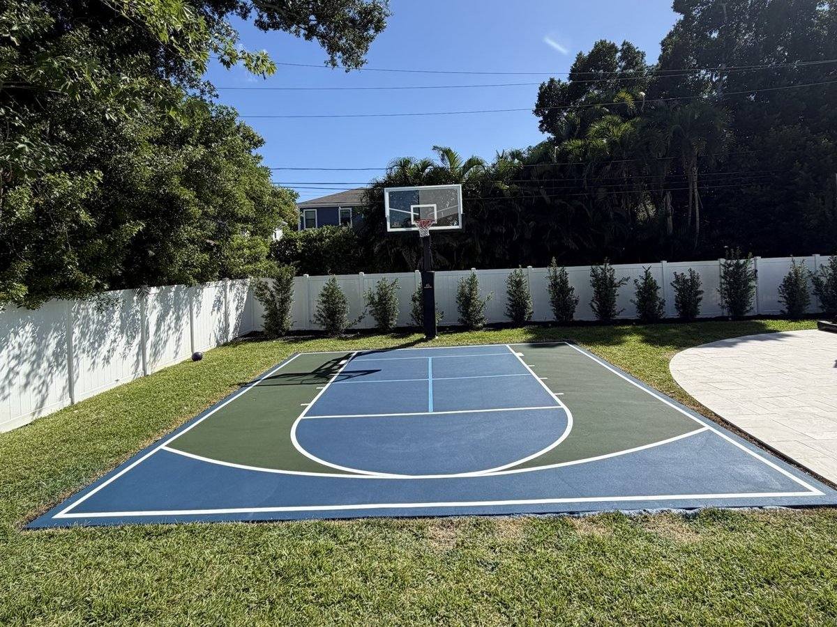 Blue and green backyard court with a basketball key, three-point arc and light-blue pickleball lines